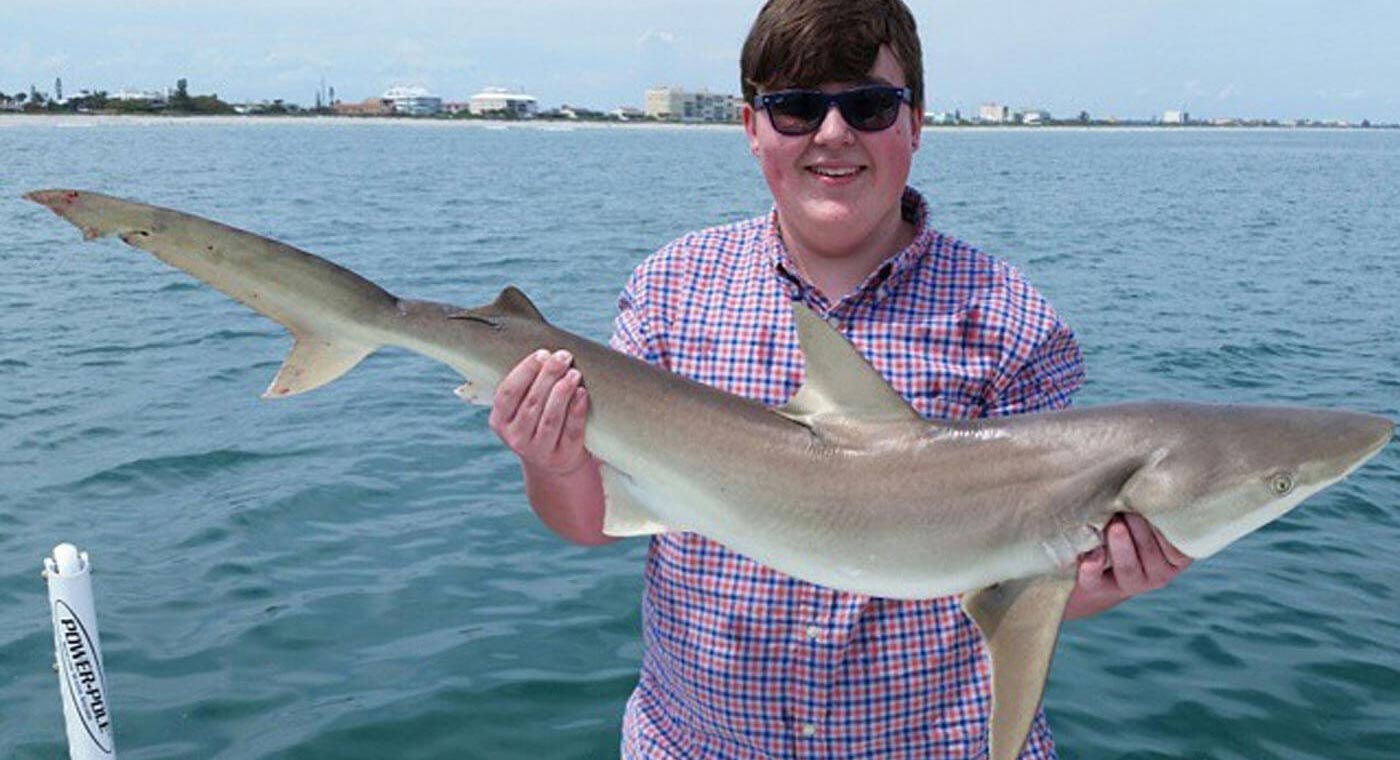 Boy holding shark at the Shark Fishing Charter in Cocoa Beach