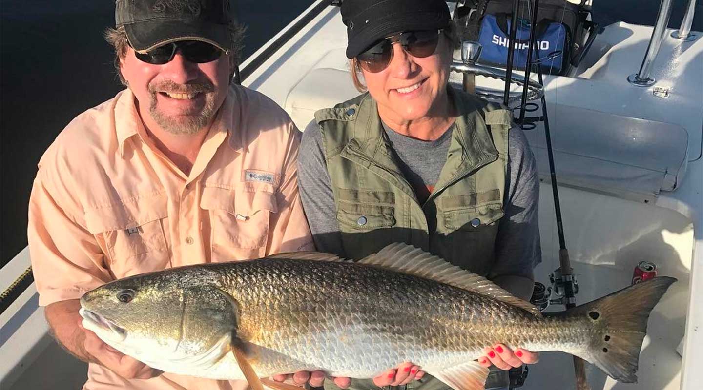 A Couple at the Cape Canaveral Fishing Charter Holding Bull Redfish